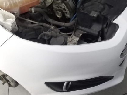 Ford blanco con el capot abierto en el taller